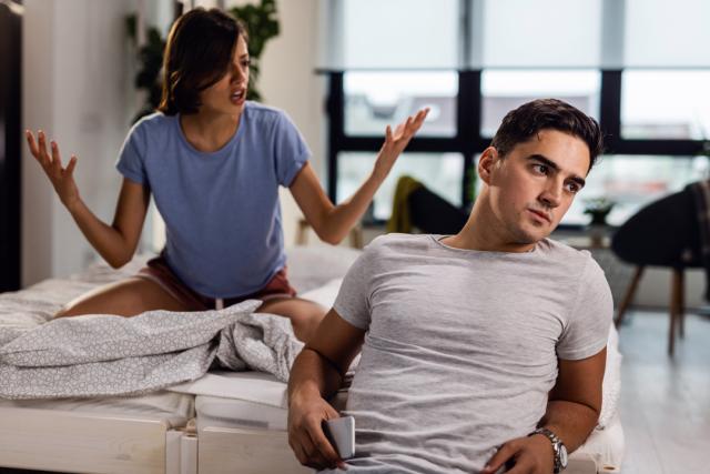 Pareja junto a una cama discutiendo